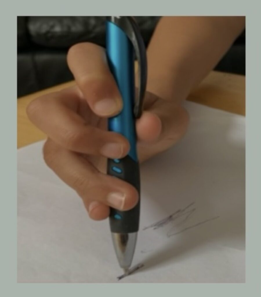 Child with hypermobile fingers holding a pen, showing handwriting difficulties.