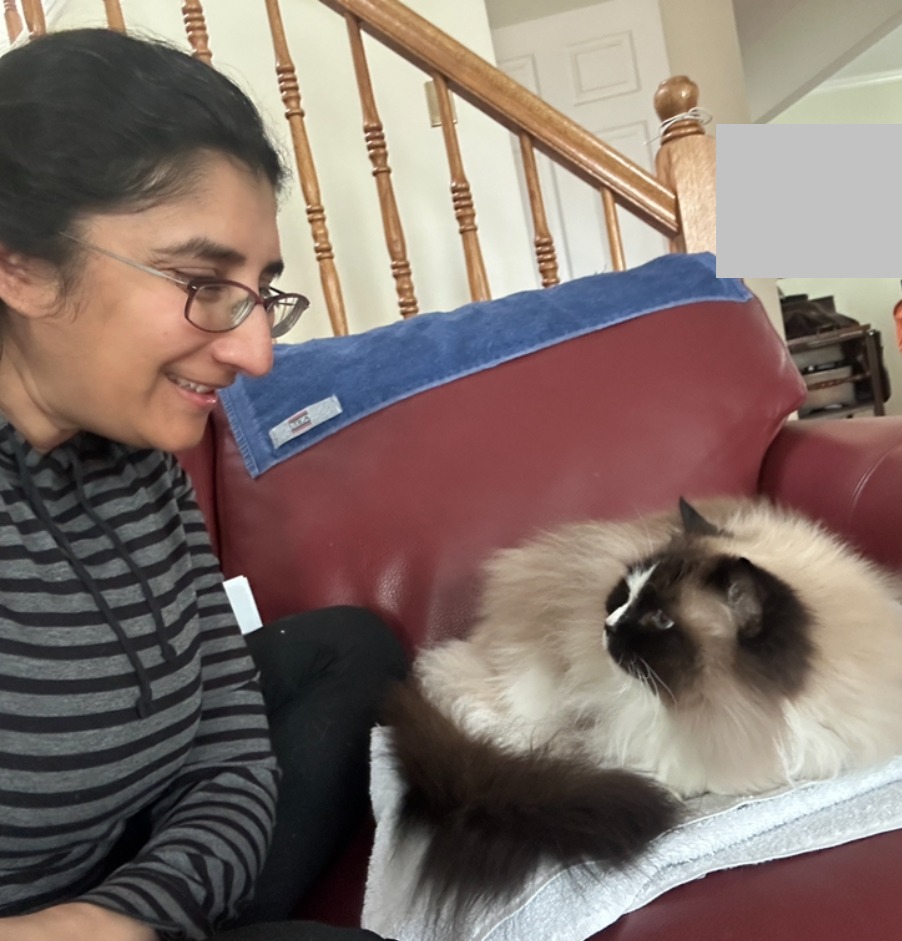 Woman on couch looking at cat affectionately and cat looking back.