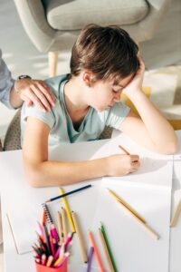 Child looking upset about writing.