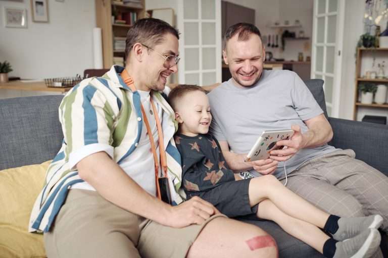 Parents and child participating in an online occupational therapy assessment using a tablet.