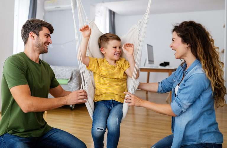 Parent and child smiling together in a hammock, showing supportive family connection while working through writing difficulties.