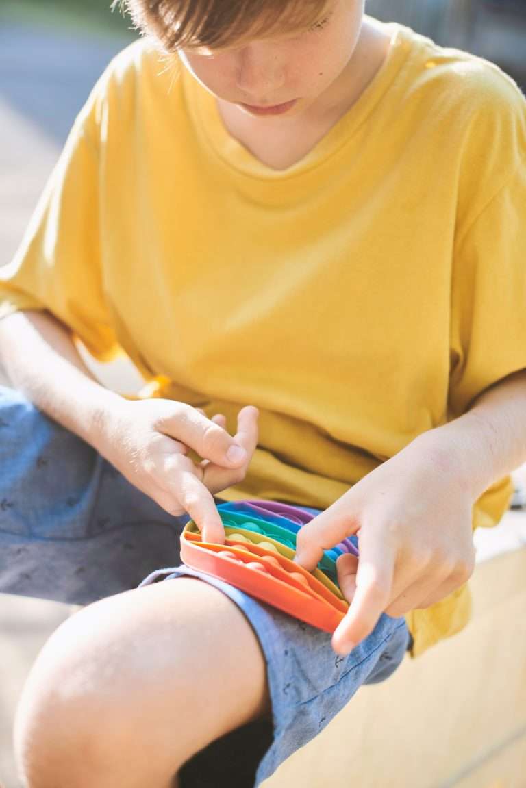 Child playing with a sensory fidget popper toy to support sensory regulation